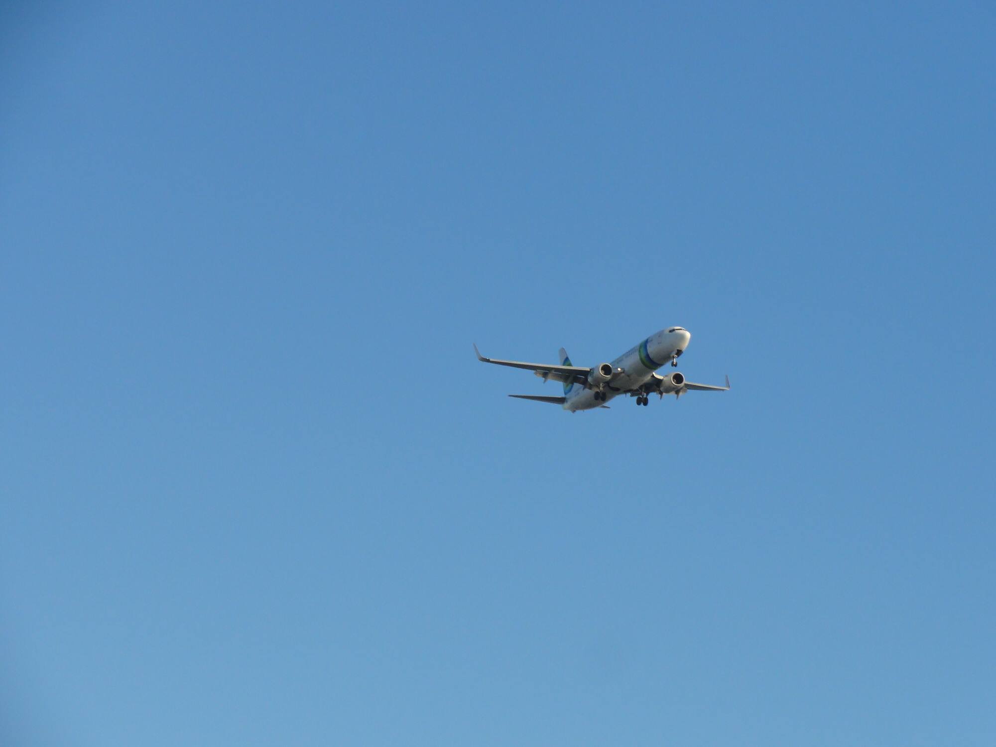 Plane flying in blue sky.